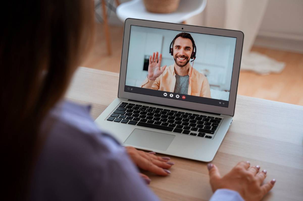 A woman engaged in a video chat with a man on her laptop.