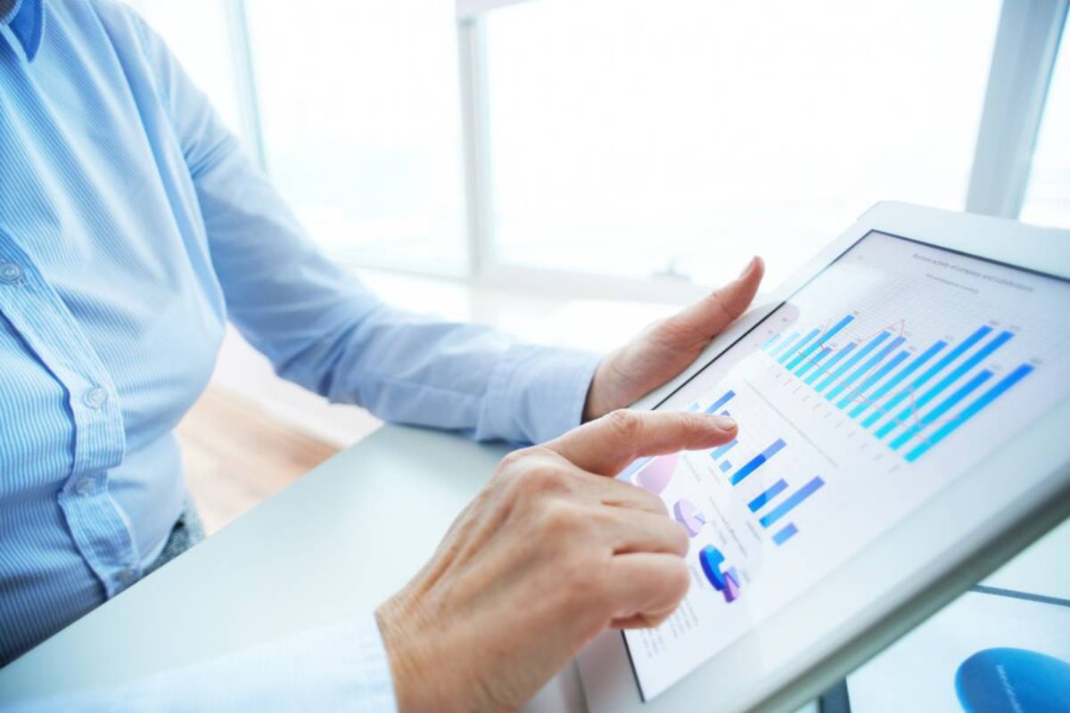 A person analyzing graphs displayed on a tablet, focused on data interpretation and insights.