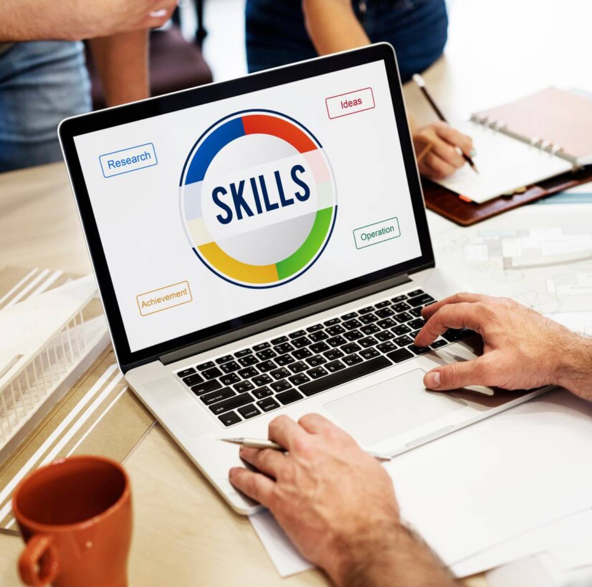 A person is focused on a laptop displaying various skills and competencies. 