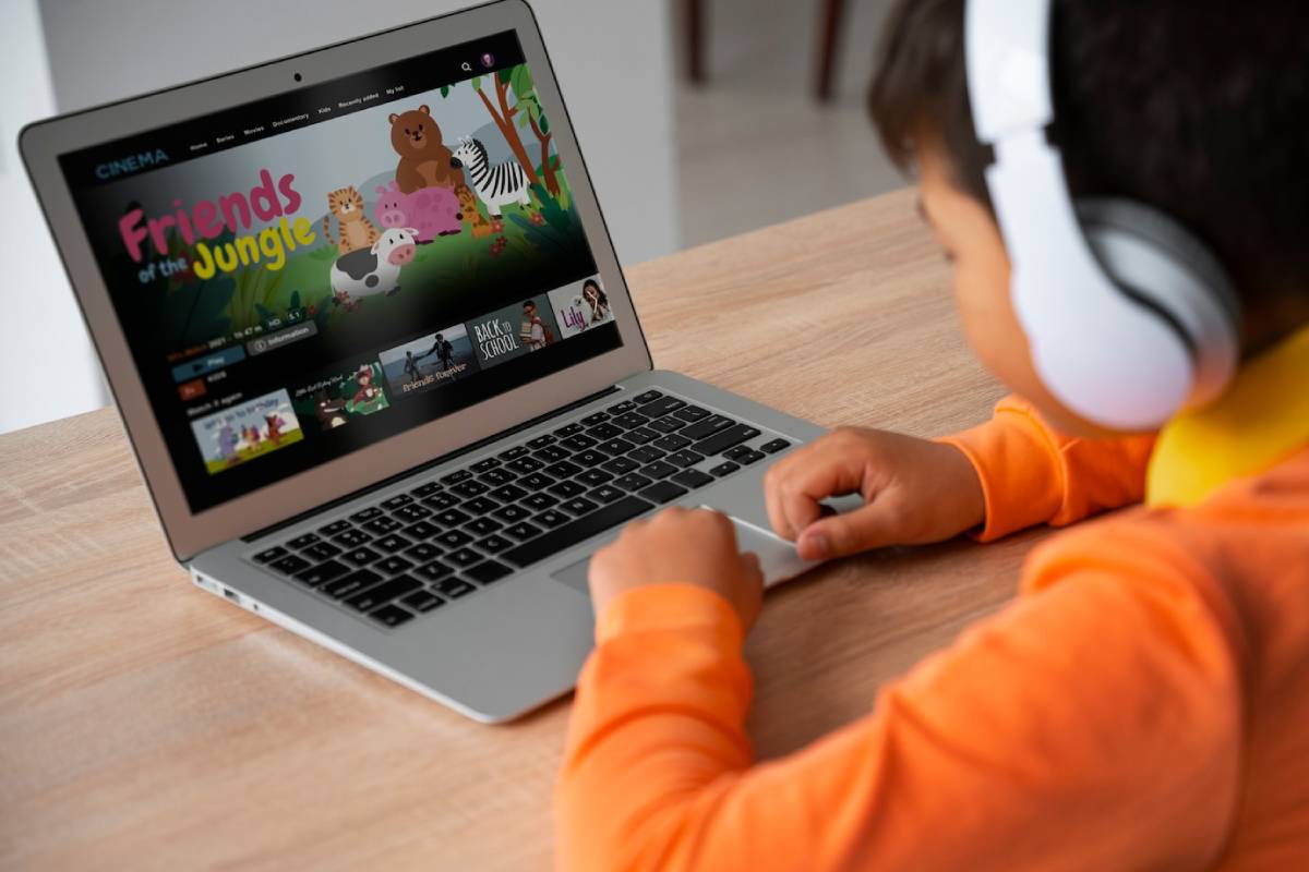 A child wearing headphones watches a colorful animated show,